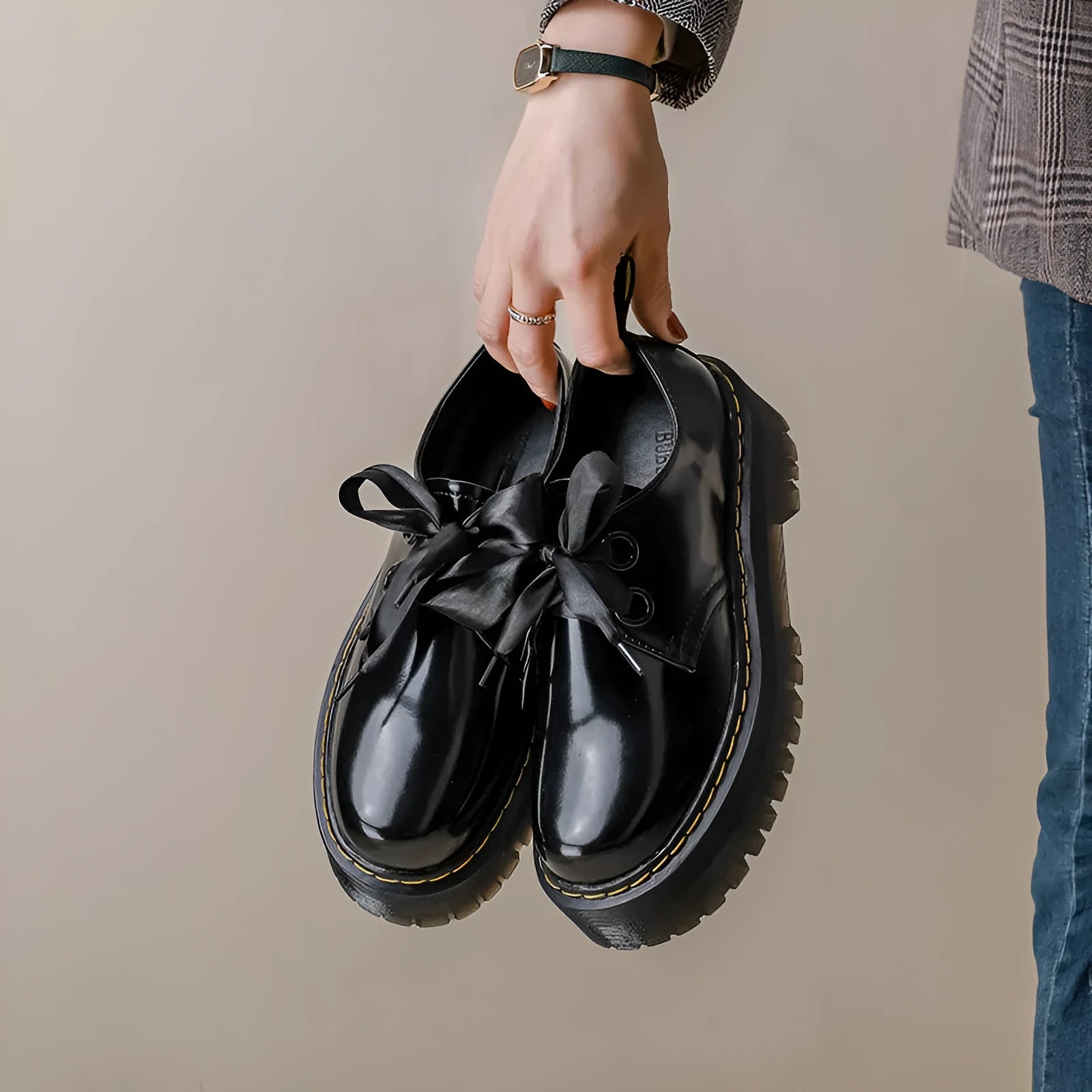 Black women's thick-soled lace-up shoes with decorative white ribbon cross straps.