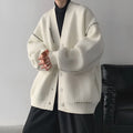Loose fit black knitted cardigan coat with long sleeves, shown open as a casual layer.