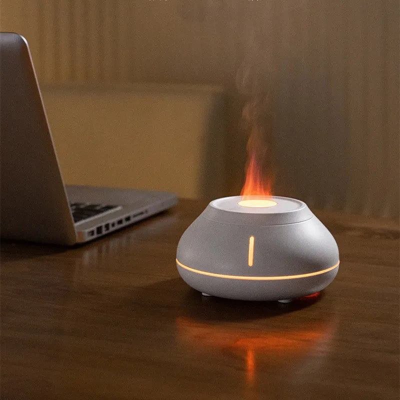 Round white aroma diffuser with colourful LED flame effect on desktop