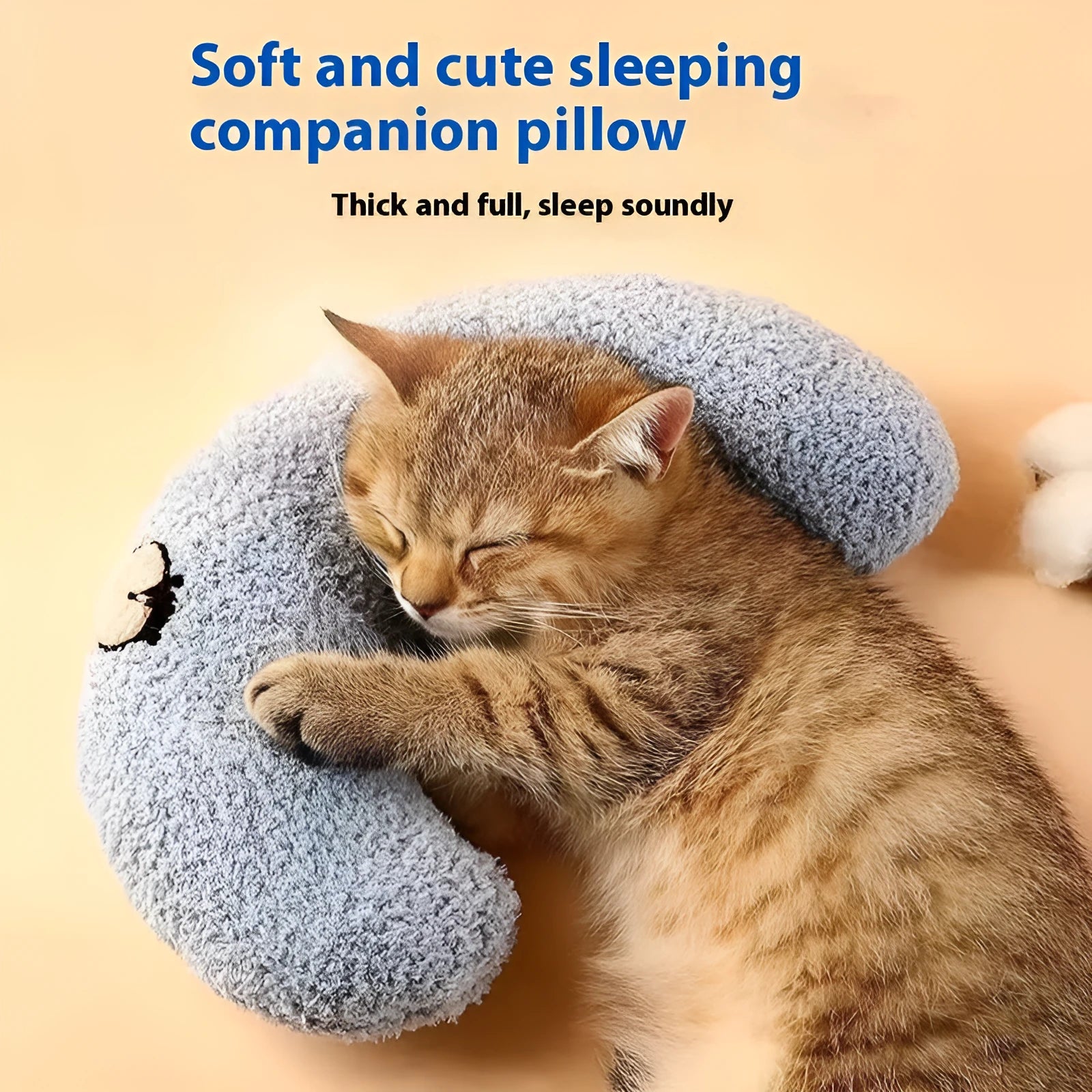 Blue U-shaped cloth pillow for cats on a wooden floor, showing its head-cradling design.