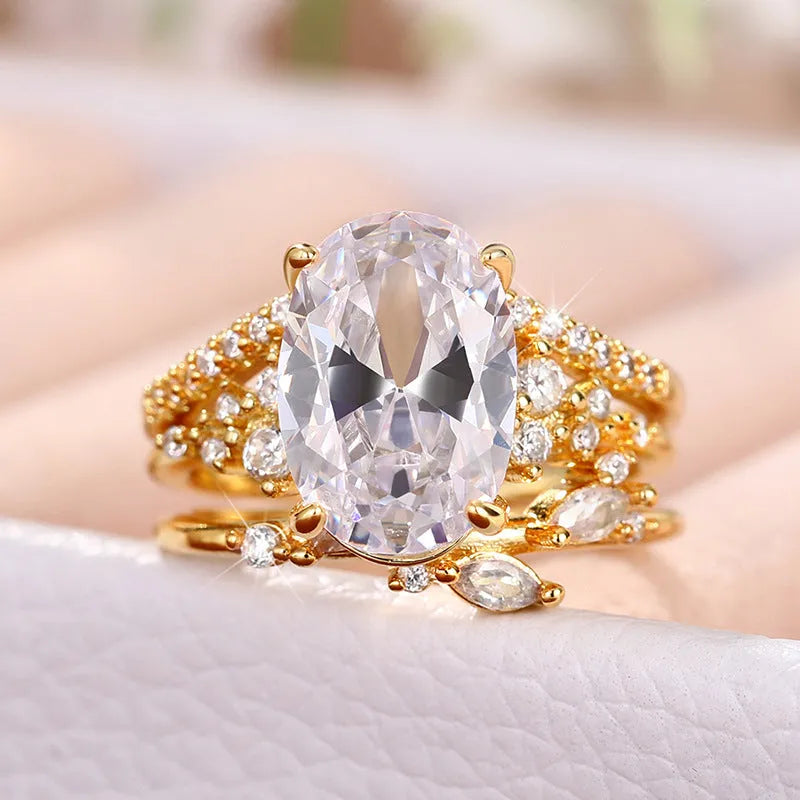 Copper zircon ring set with goose egg-shaped cut in Q681 gold on hand, three rings with flower and geometry shapes