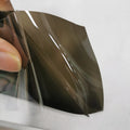 A roll of 30cm wide dark grey car lamp protective film for headlight and taillight protection.
