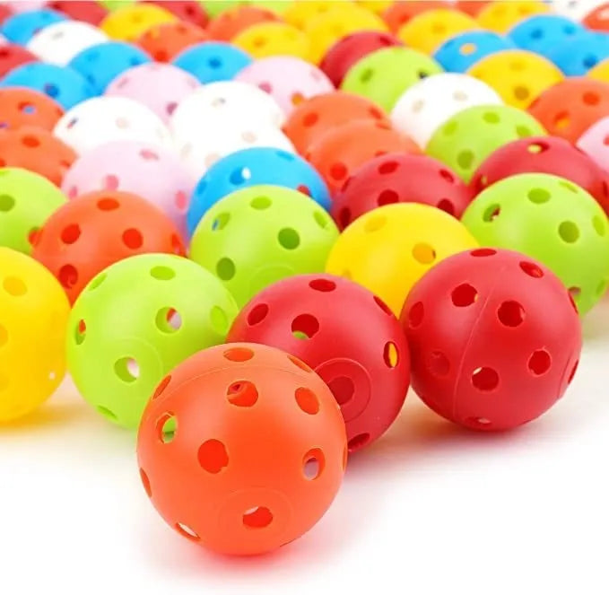 Multi-colour golf practice balls with 26 holes on a green surface.