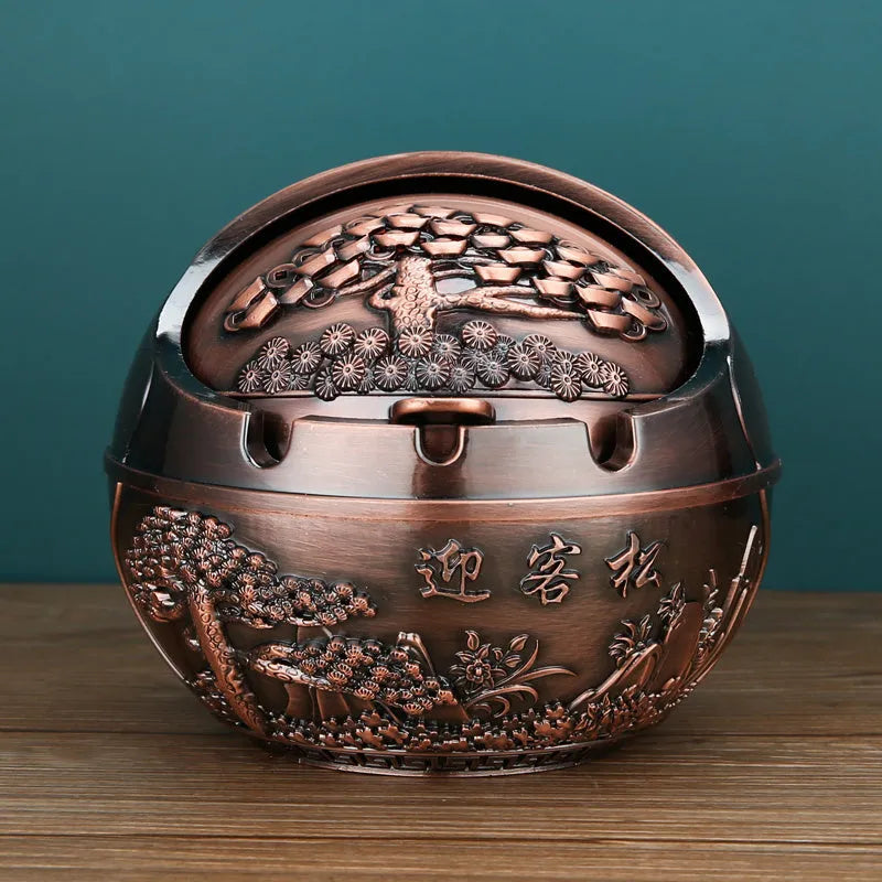 Alloy decorative ashtray in bronze with ornate peacock motif and cigarette extinguishing slot.