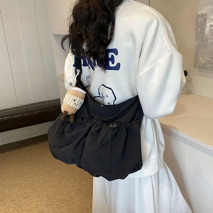 Foldable pleated polyester crossbody bag in street style, showing split pockets and a green colour option.