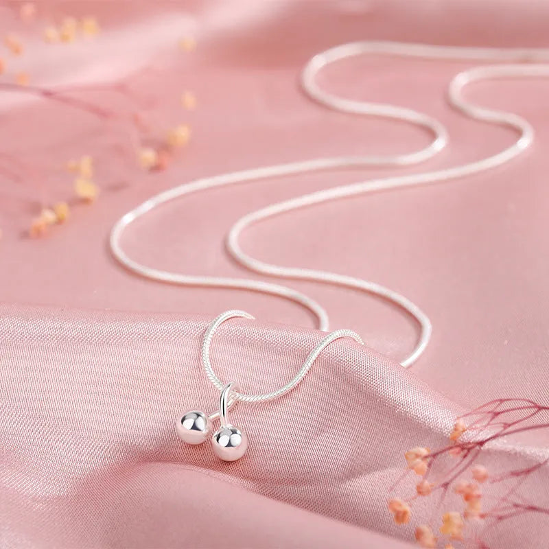 Silver cherry fruit pendant necklace on an adjustable snake bone chain for women.