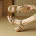Women's beige open toe platform sandals with a round toe design and a thick rubber sole on a wooden surface.