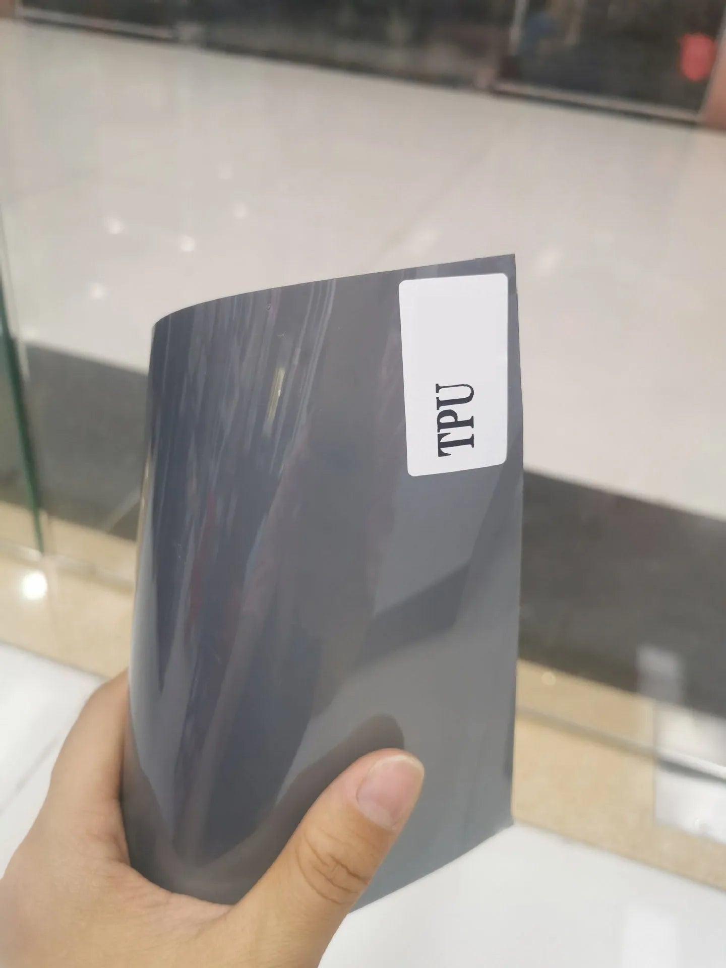 A roll of 30cm wide dark grey car lamp protective film for headlight and taillight protection.