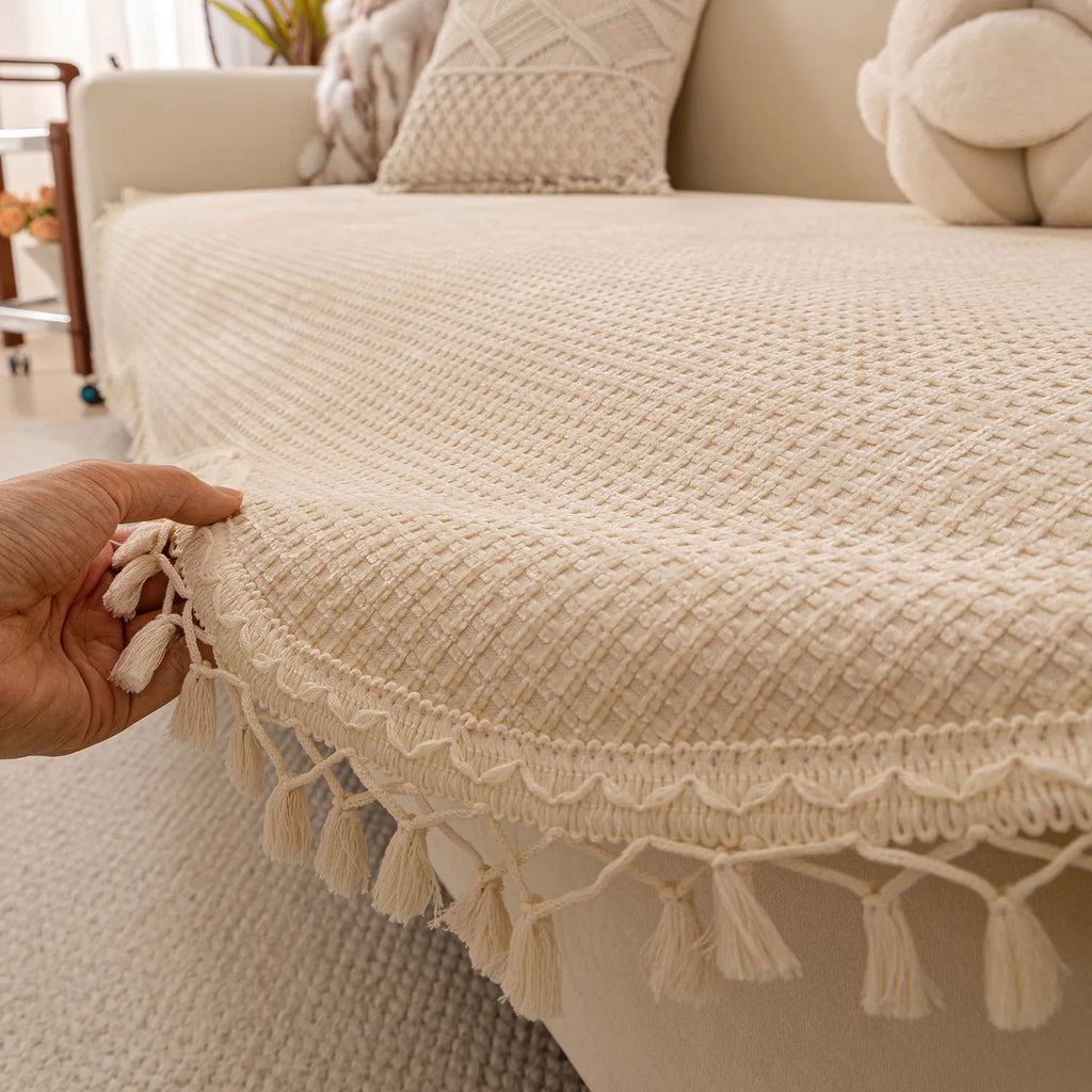 Ivory white non-slip short plush polyester sofa cover with tassle fringe on a sofa seat