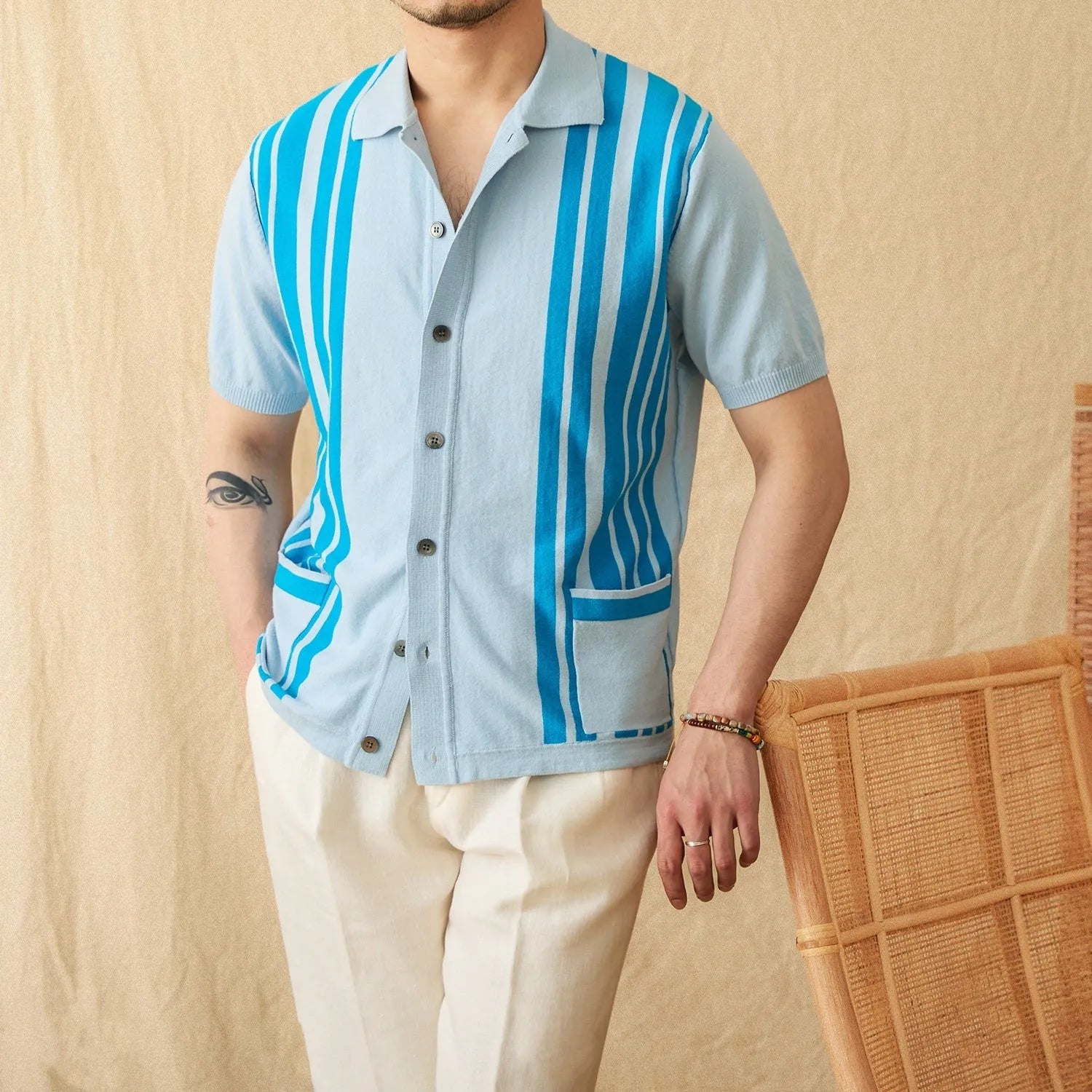 A royal blue striped lapel cardigan polo shirt on a hanger, showing short sleeves and knitted fabric.