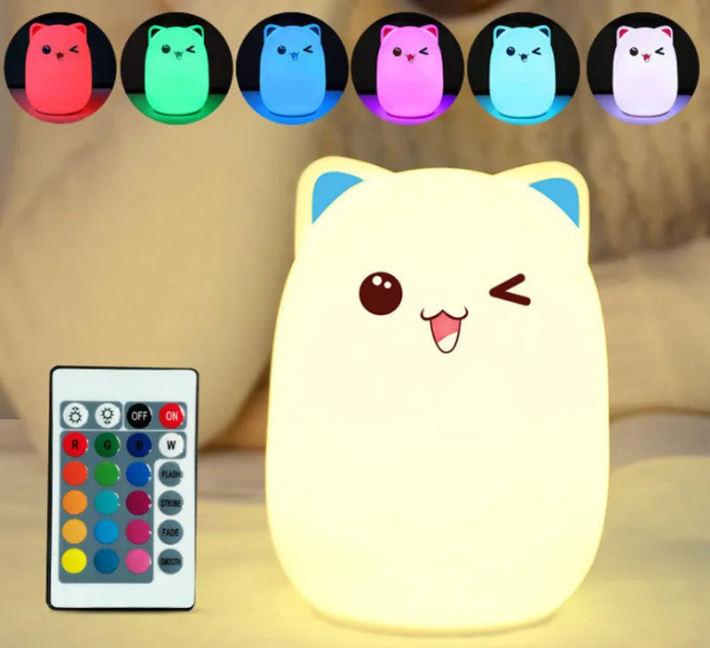 Cartoon silicone clapping night lamp in pink with USB charging cable on a bedside table