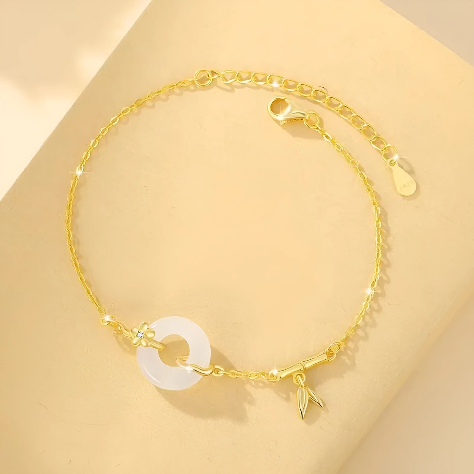 Silver gold electroplated women's bracelet with a white chalcedony stone and prominent peace buckle clasp on a 22 cm band.