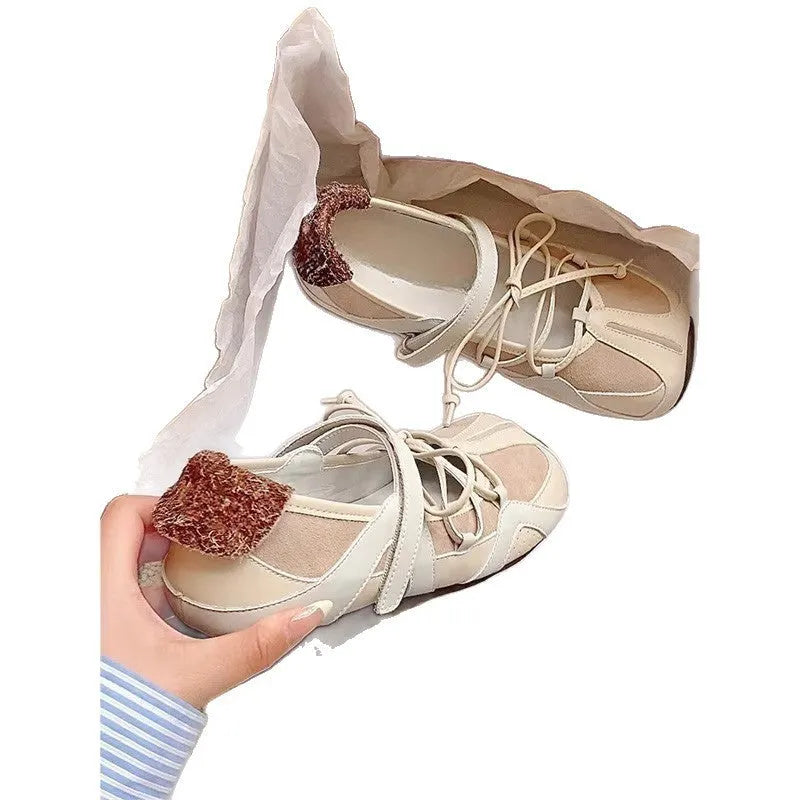Beige vintage Mary Jane ballet flats with a round toe, lace-up front, and a mid-height English muffin heel.