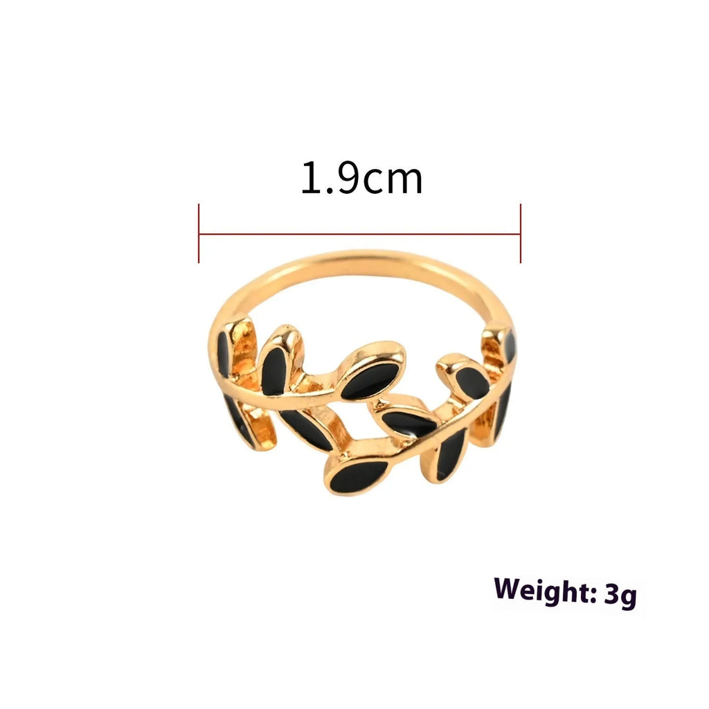 Gold electroplated acrylic ring with a geometric leaf and flower design on a model's index finger.