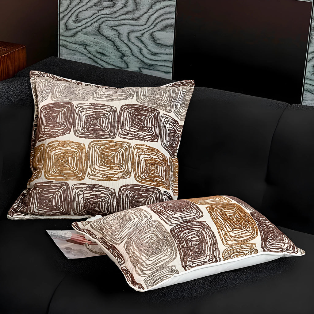 Cream and coffee coloured abstract coil pattern square and rectangular polyester cushion covers.