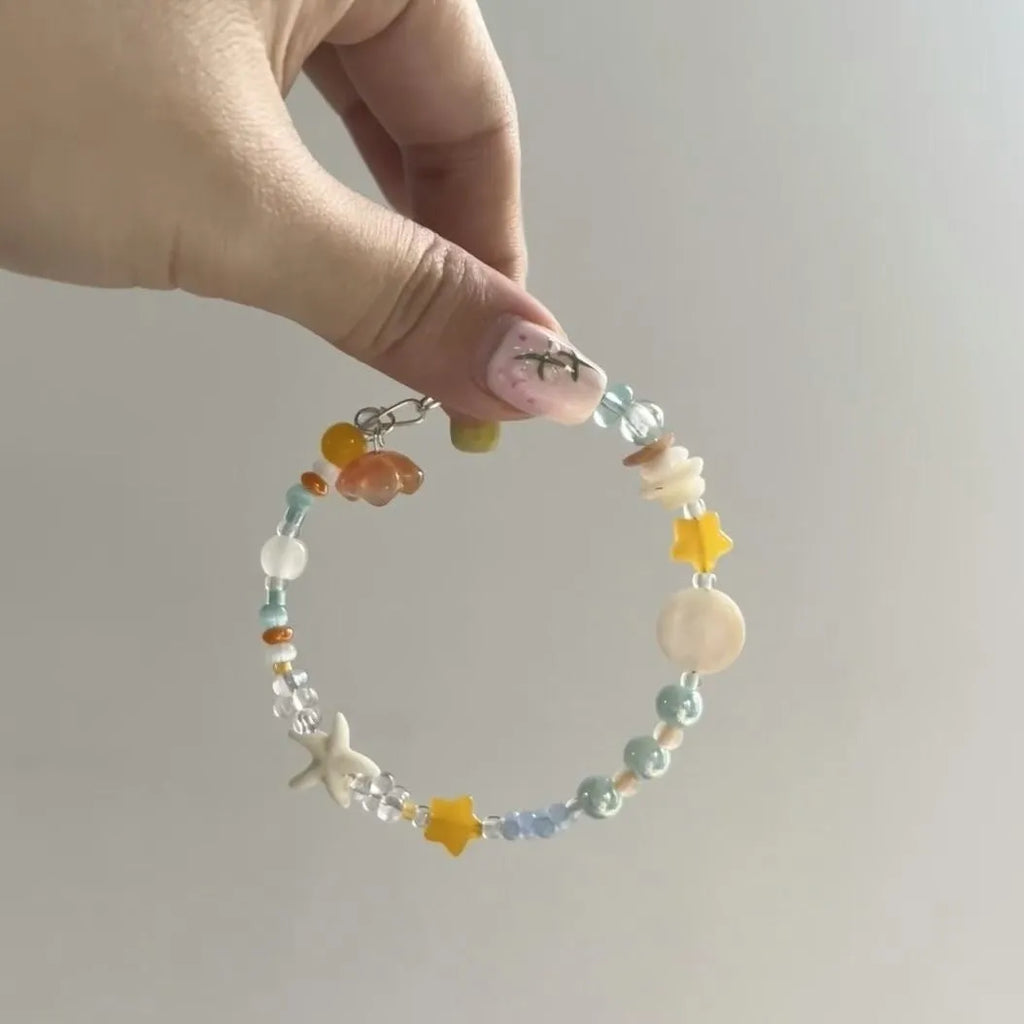 Women's orange summer bracelet with a diamond-shaped alloy centrepiece on a mixed-material band.