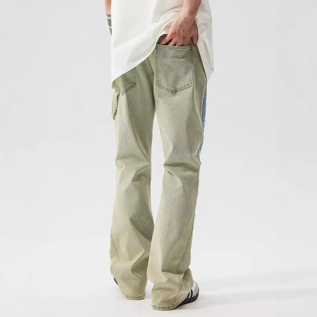 Yellow and blue retro patchwork jeans with splash-ink and distressed detailing on a mid-rise denim fit