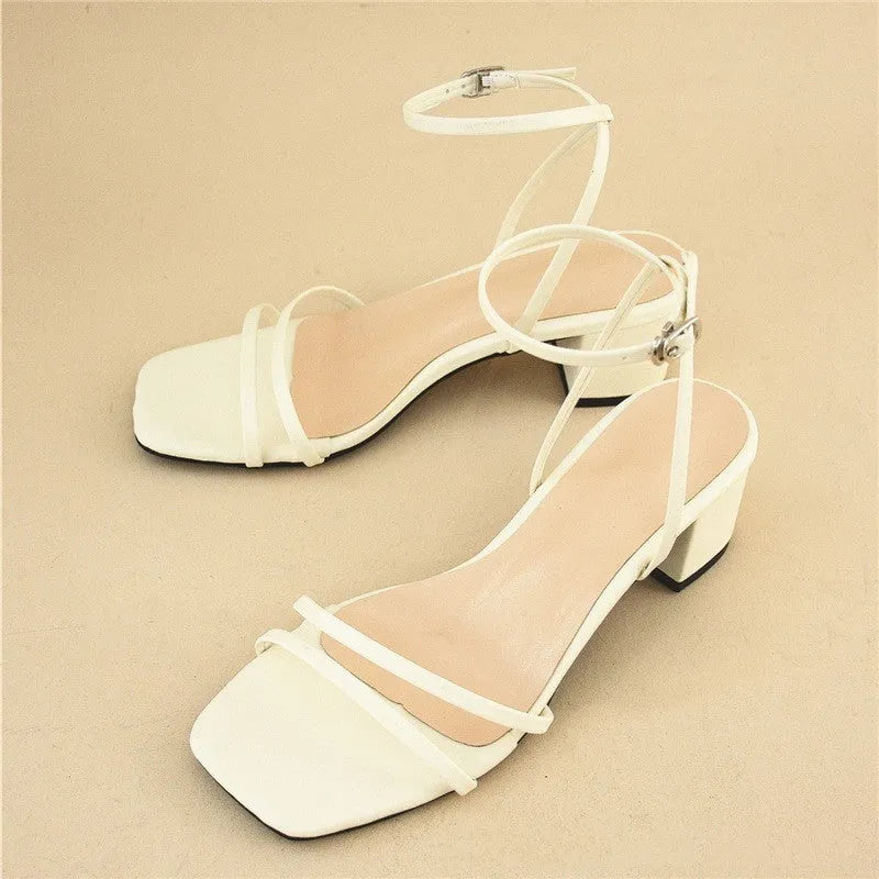 Beige women's stiletto sandals with chunky heel, square toe, and ankle buckle.