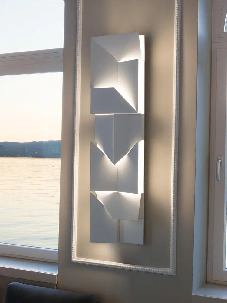 Minimalist rectangular wall lamp in matte white finish, shown in a living room setting.