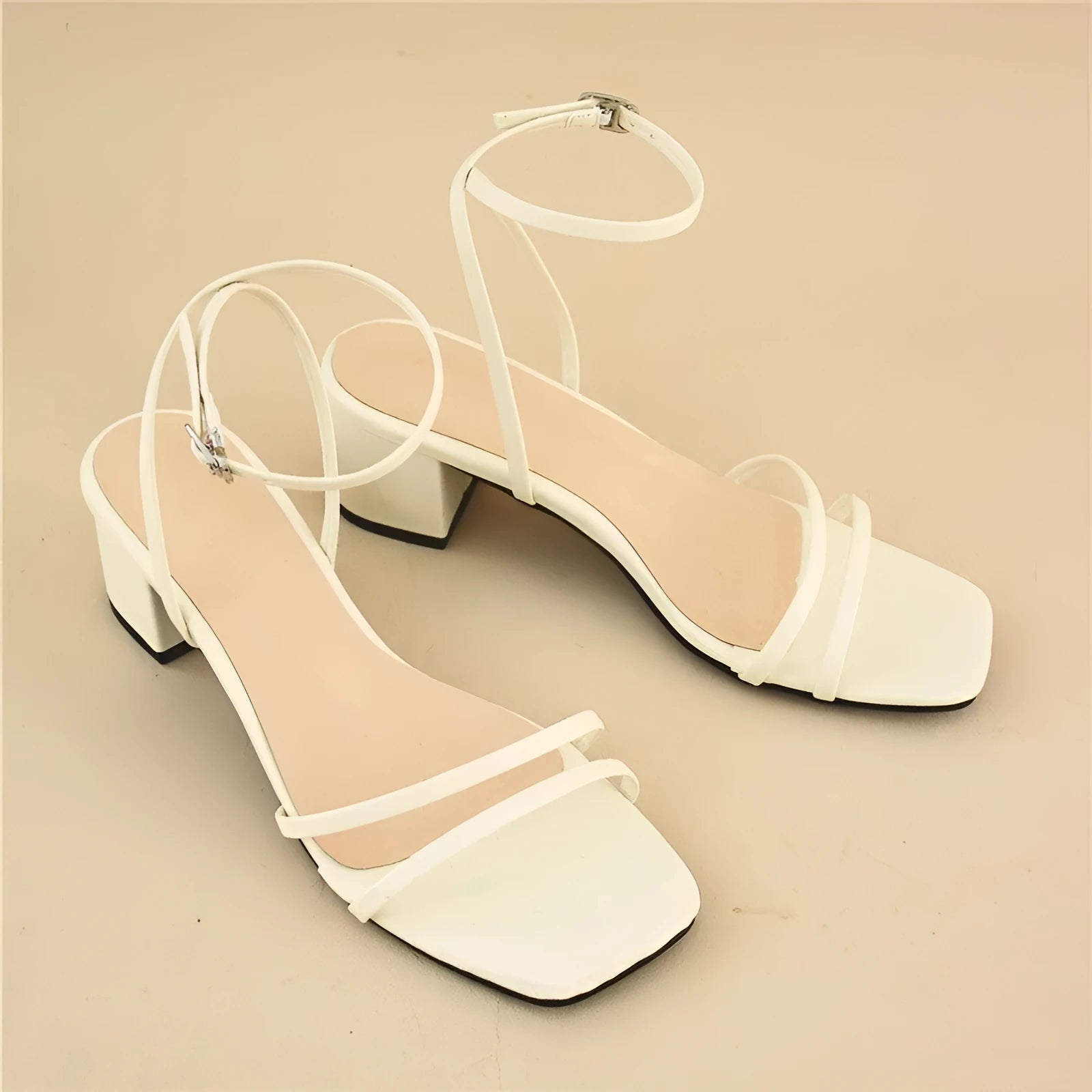 Beige women's stiletto sandals with chunky heel, square toe, and ankle buckle.