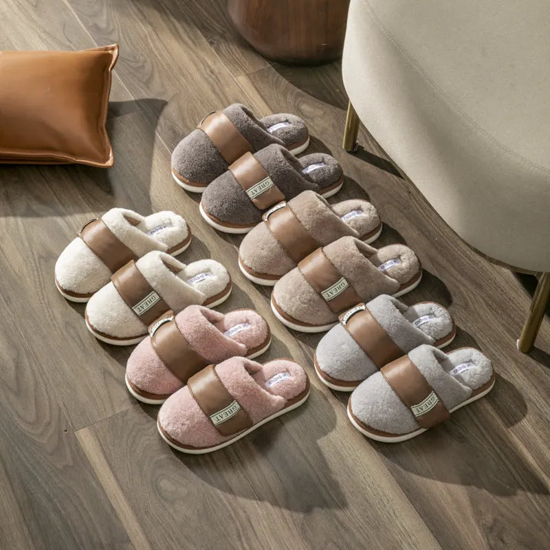 Beige women's plush slippers with a Velcro strap and non-slip plastic sole on a wooden floor.