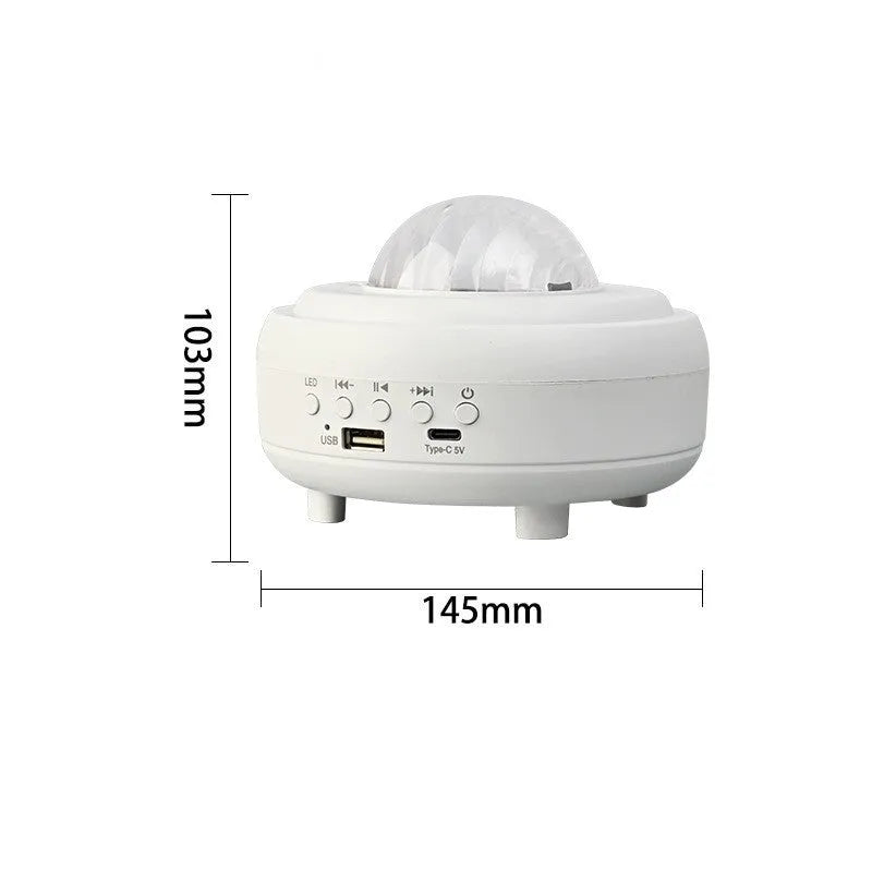 White Galaxy Star Projector Night Light on a table projecting blue starry sky onto a ceiling.