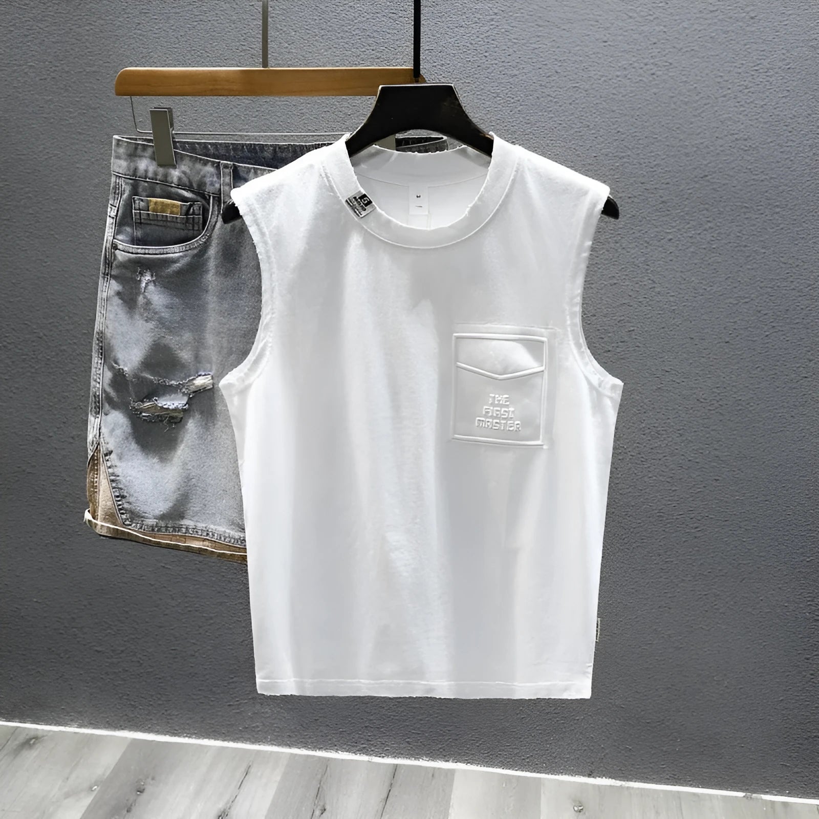 Women's loose fit cotton sleeveless vest in white on a hanger, showing straight hem and solid colour.