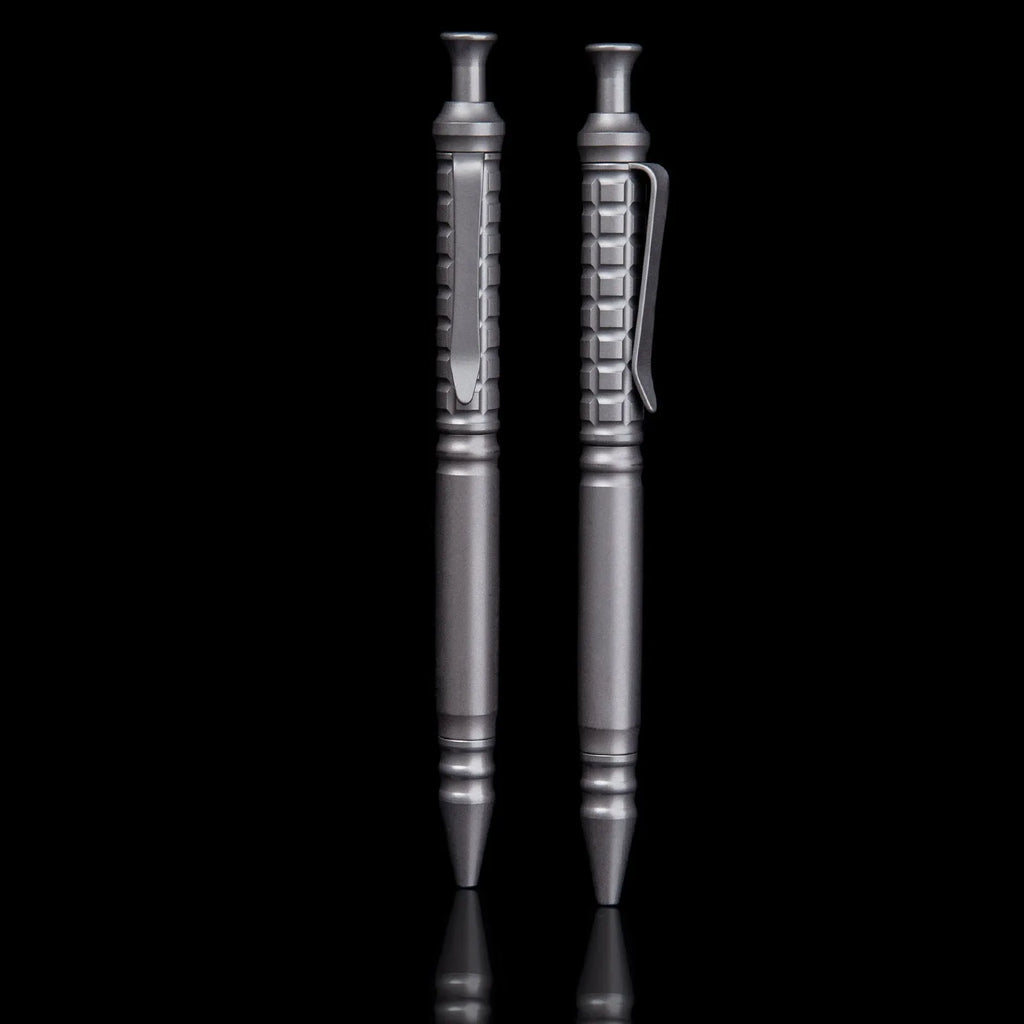 Gunmetal grey titanium alloy tactical pen with push-action mechanism on a gift box.