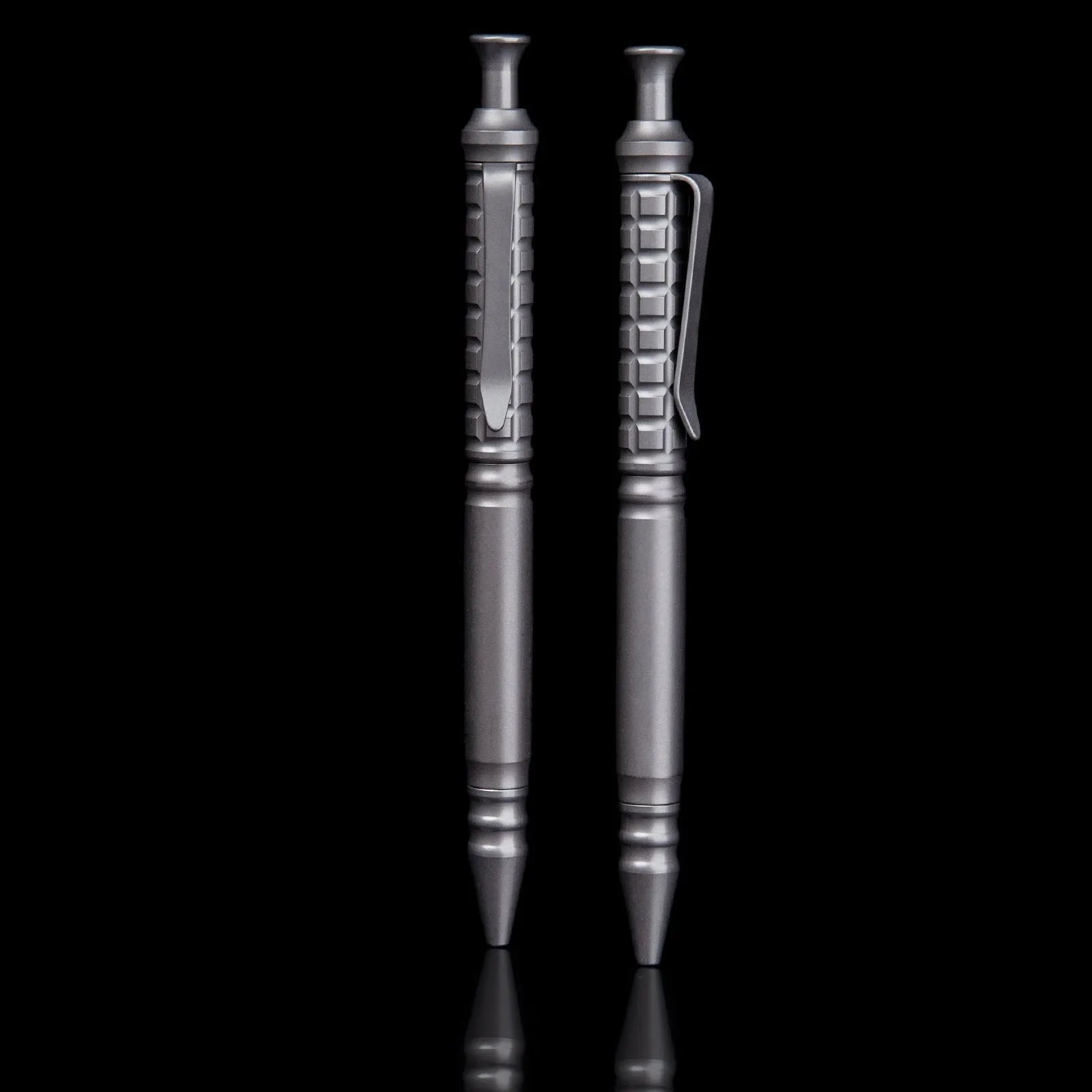 Gunmetal grey titanium alloy tactical pen with push-action mechanism on a gift box.