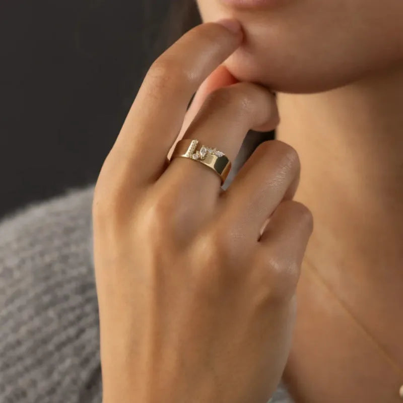 Gold plated women's ring with a shining zircon stone on a model's hand.