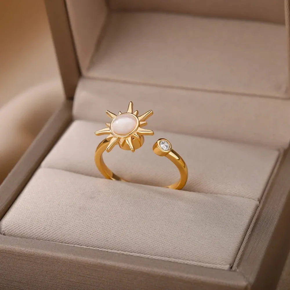 A geometric gold-coloured ring with an adjustable opening, shown rotating on a finger.