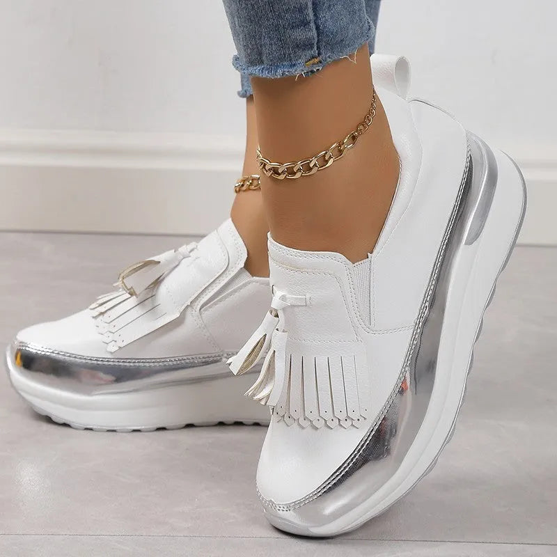 Black women's platform shoes with a tassel on the front and a thick muffin wedge heel.