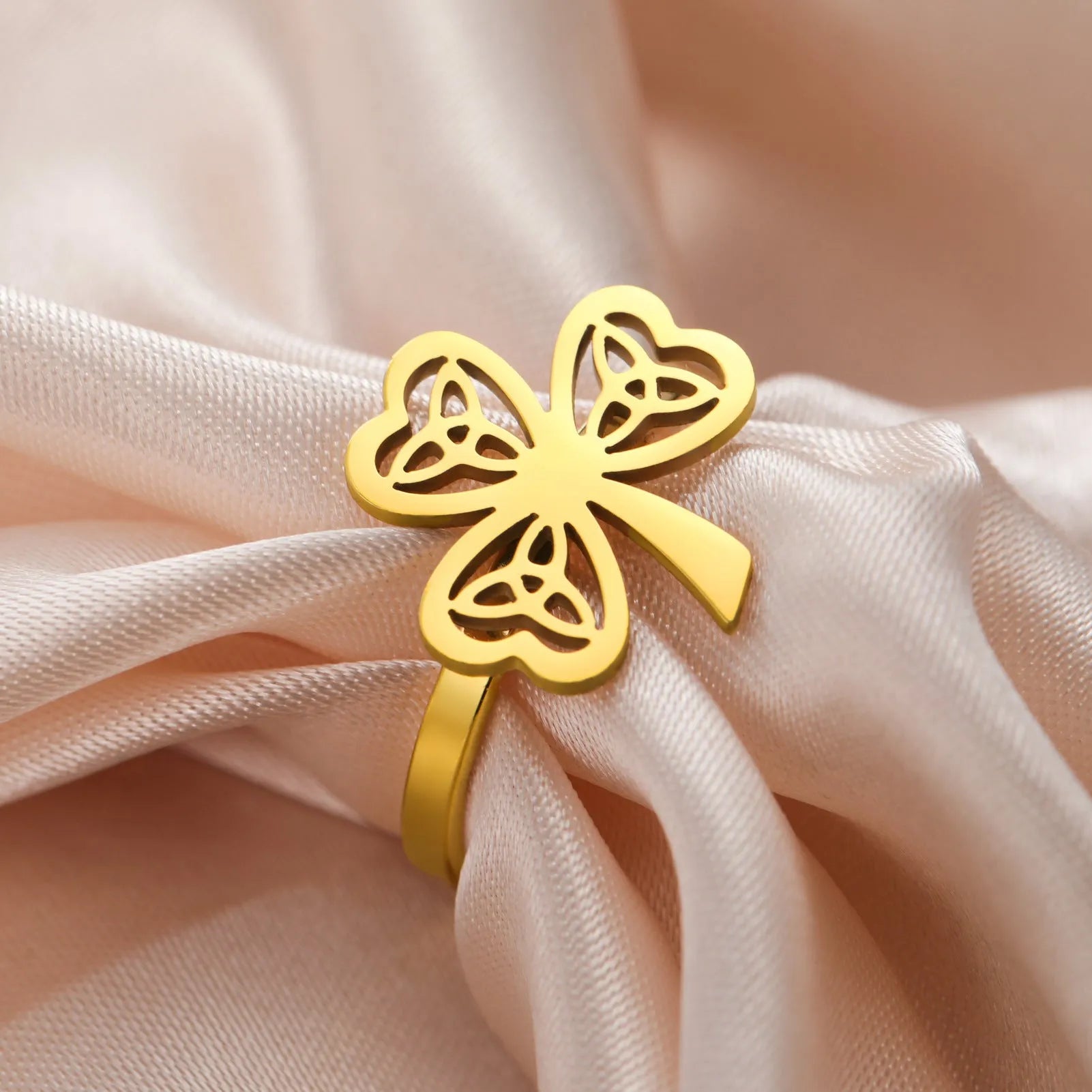 Women's stainless steel lucky hollow ring in gold colour on a hand, showing hollow band construction.