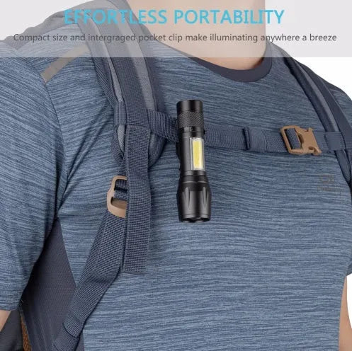 Small black aluminium telescopic LED flashlight with clip, showing zoom adjustment and button switch.