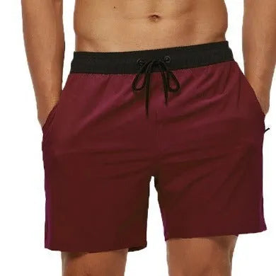 Men's blue training shorts with stitching waist detail, drawstring, and a zipped pocket on the leg.