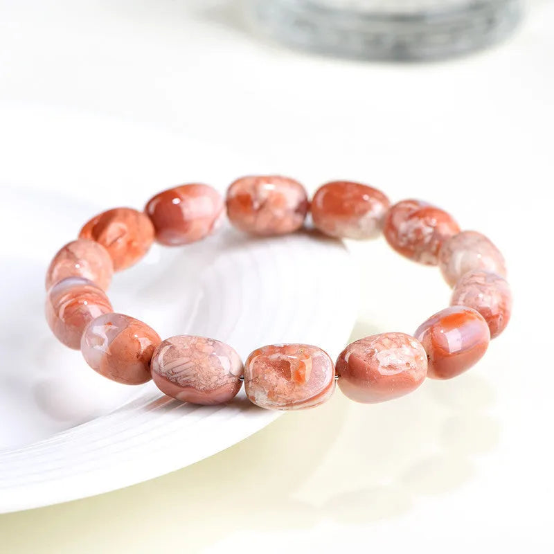 Natural cherry agate bracelet with geometric 10x14mm barrel beads and ruyi details on a wrist.