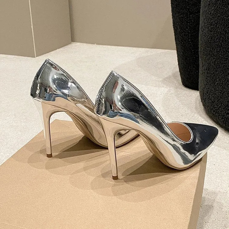 Gold and silver pointed toe slip-on stiletto heel pumps on a white background