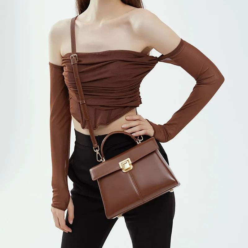 Dark brown genuine leather women's shoulder bag with a clasp, showing its horizontal square shape and shoulder strap.