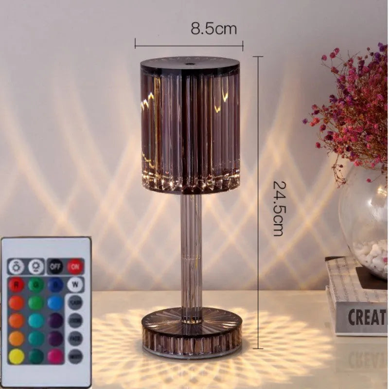 Modern crystal table lamp with a diamond-faceted shade on a metal stand, showing amber colour option.