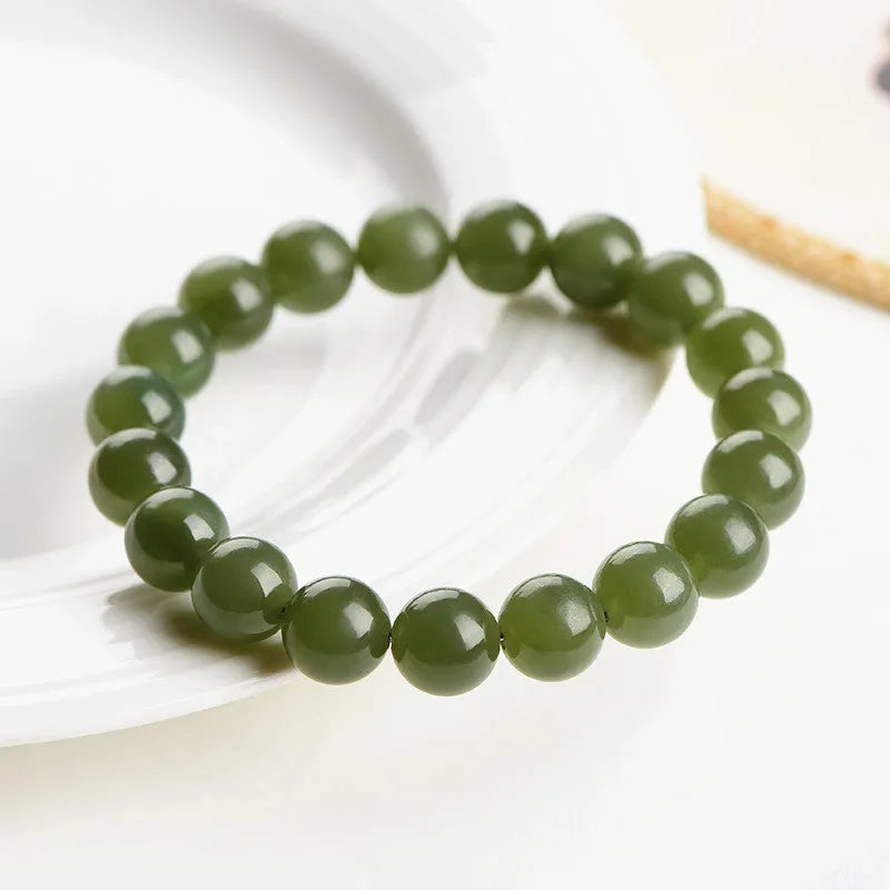 Polished Hetian jade bead bracelet in light or deep clear water colour on a wrist.