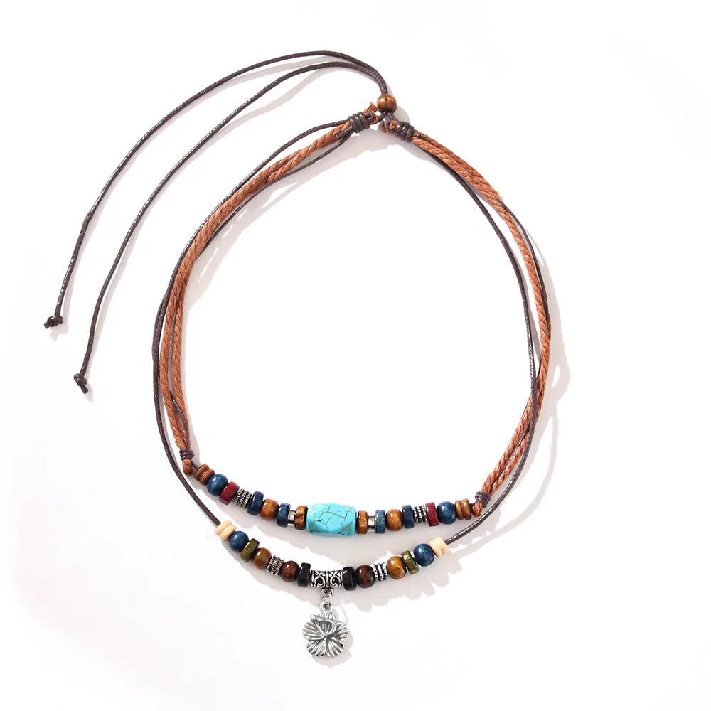 Turquoise wooden bead necklace with alloy geometric flower pendant on brown wax rope cord