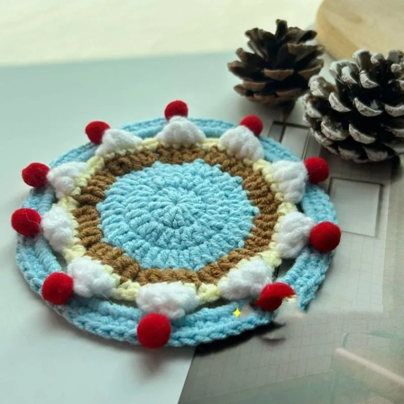 A single 9cm round wool coaster and its decorative cake-themed storage bag.