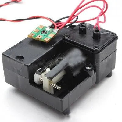 Black remote control tank model smoke box accessory with LED light on a model chassis.