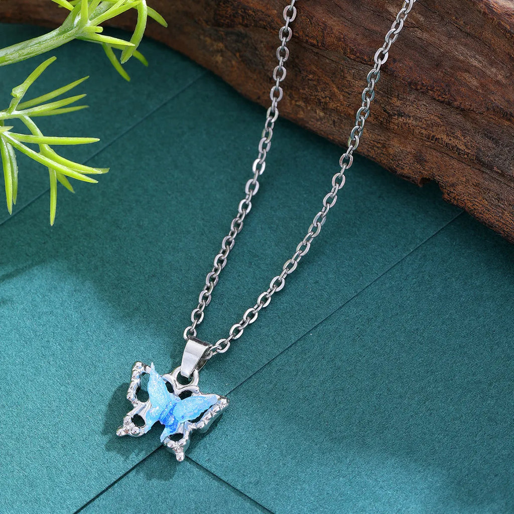 Blue three-dimensional butterfly pendant necklace for women on a light background