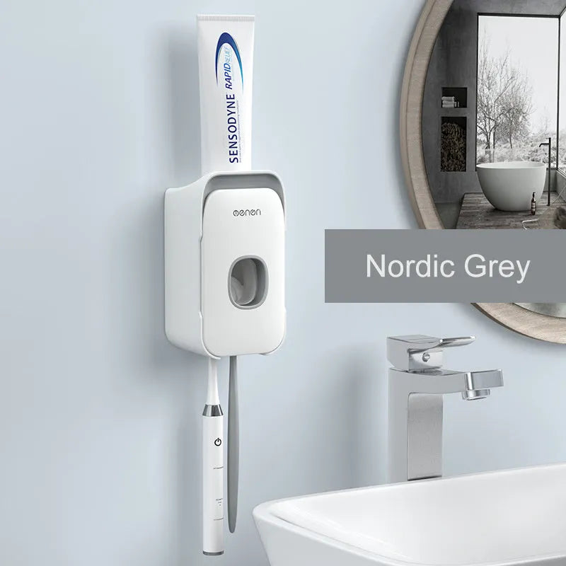 Blue automatic toothpaste dispenser mounted on a bathroom wall with a push-button for one-handed use.
