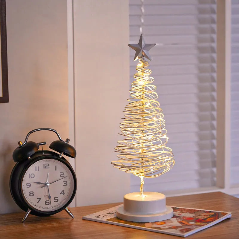 Wrought iron metal LED Christmas tree spiral light with warm white illumination on tabletop