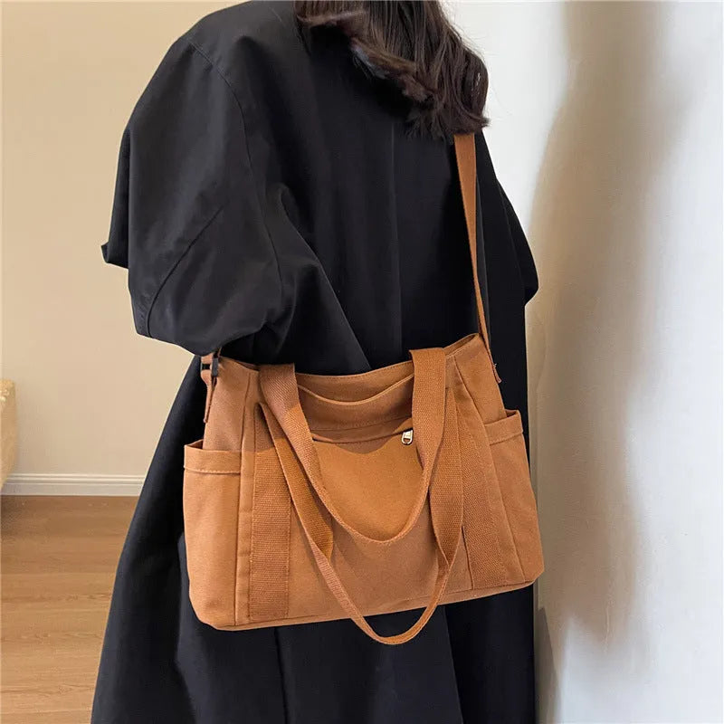 Large solid colour polyester canvas shoulder tote bag for women with outer pocket.