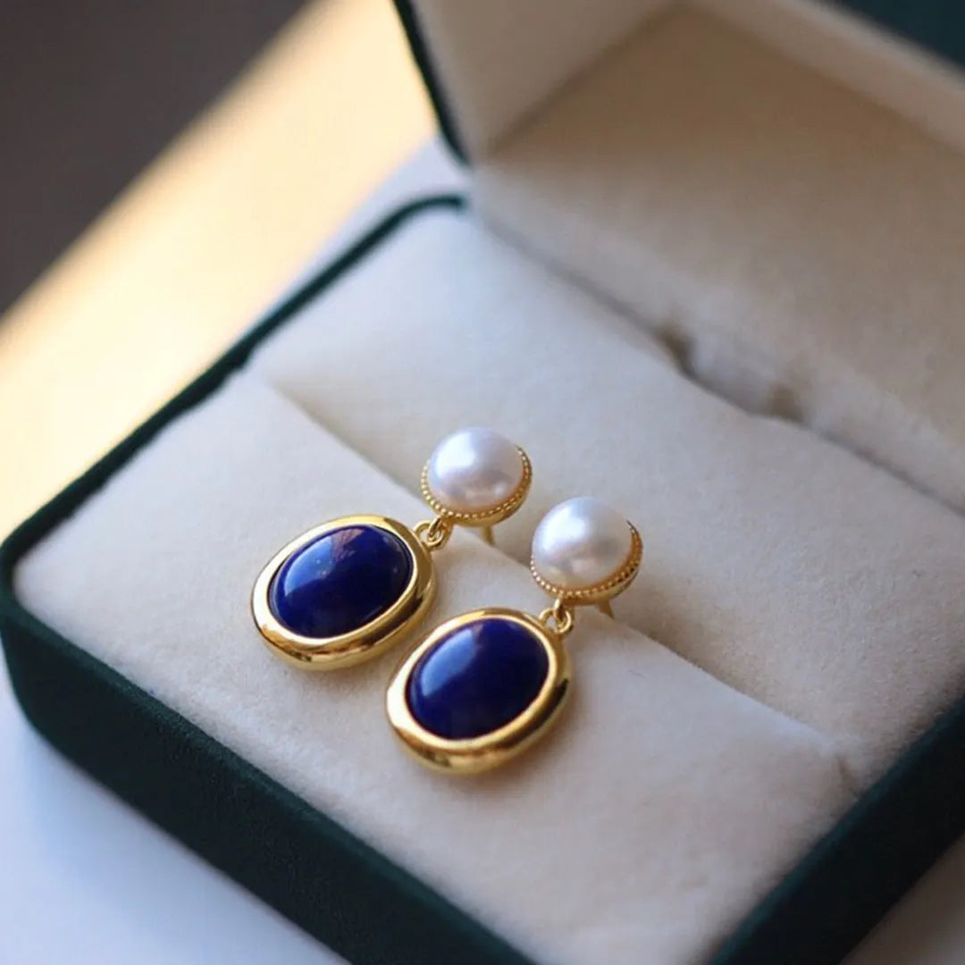 A pair of simple sterling silver earrings with a blue lapis lazuli pearl and auspicious patterns.
