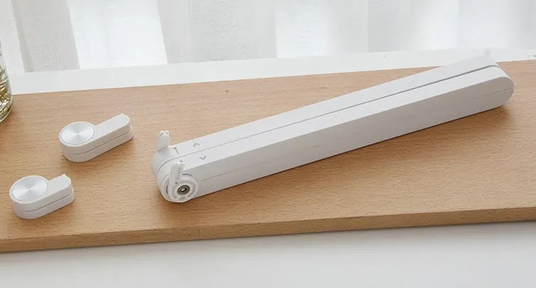 White foldable laptop stand bracket for Apple MacBook on a desktop.