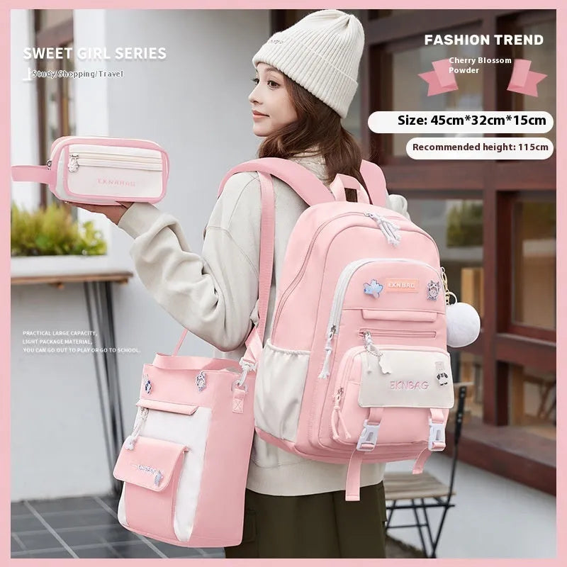 A girls' school backpack in Oxford cloth, featuring curved shoulder straps, shown in a choice of colours including pink, blue, and black.
